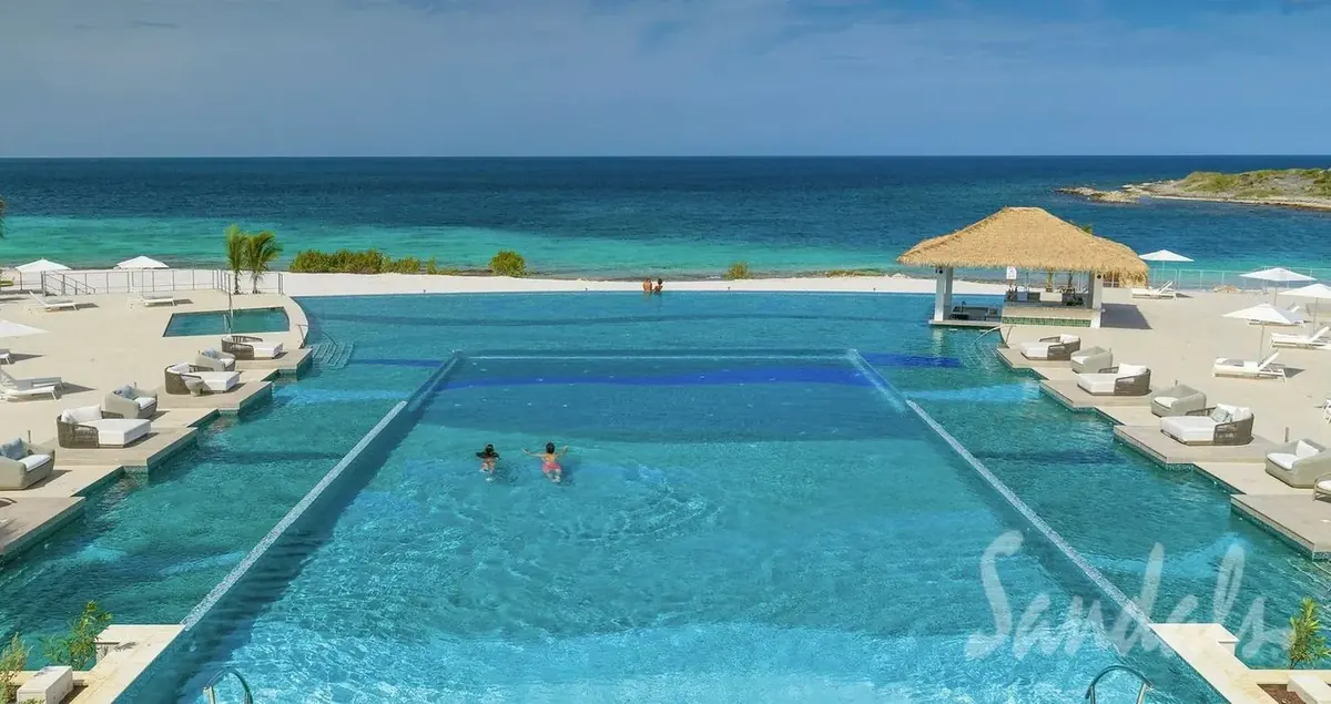 Dos Awa bi-level infinity pool at Sandals Royal Curaçao overlooking the Caribbean Sea with swim-up bar